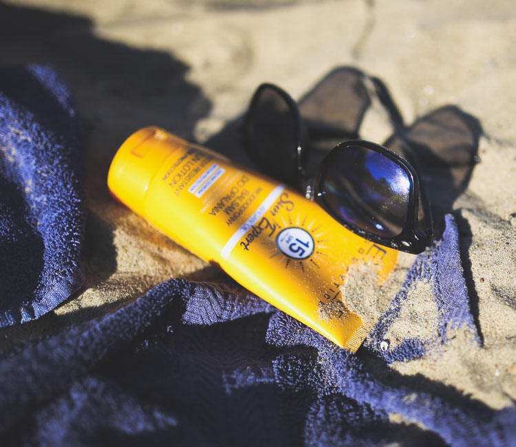 Sunblock and Sunglasses on Beach Sunblock and Sunglasses on Beach